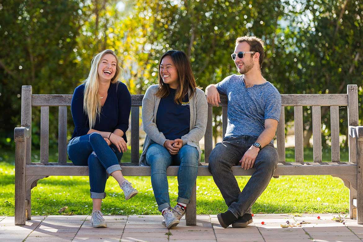 young alumni sitting on bench