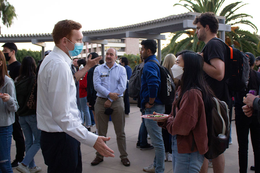 Students engage in conversation with alum