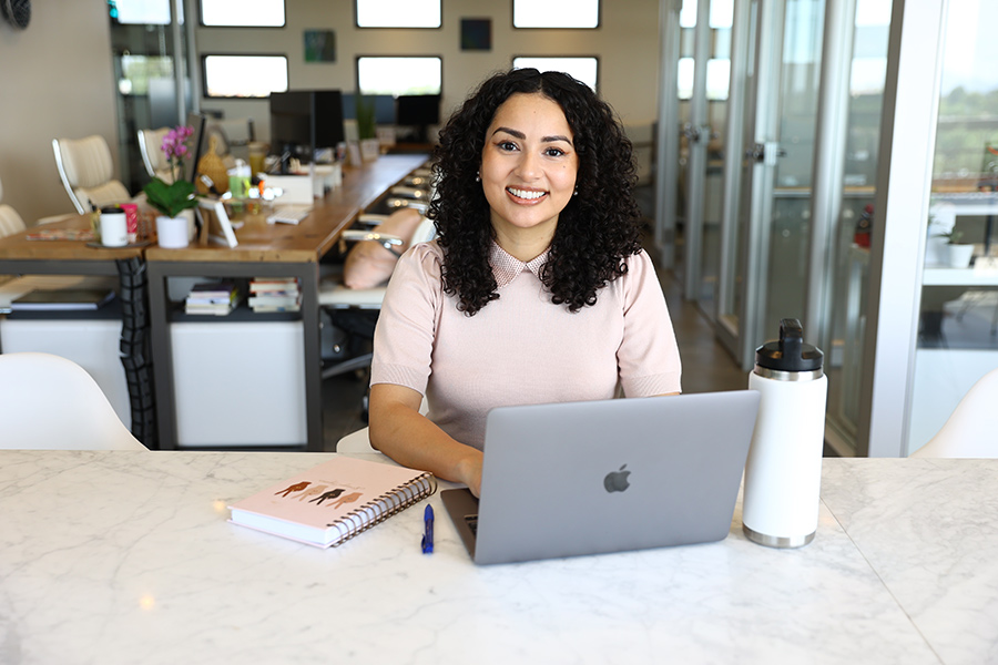 Giovanna Gonzalez '11 smiling with her laptop